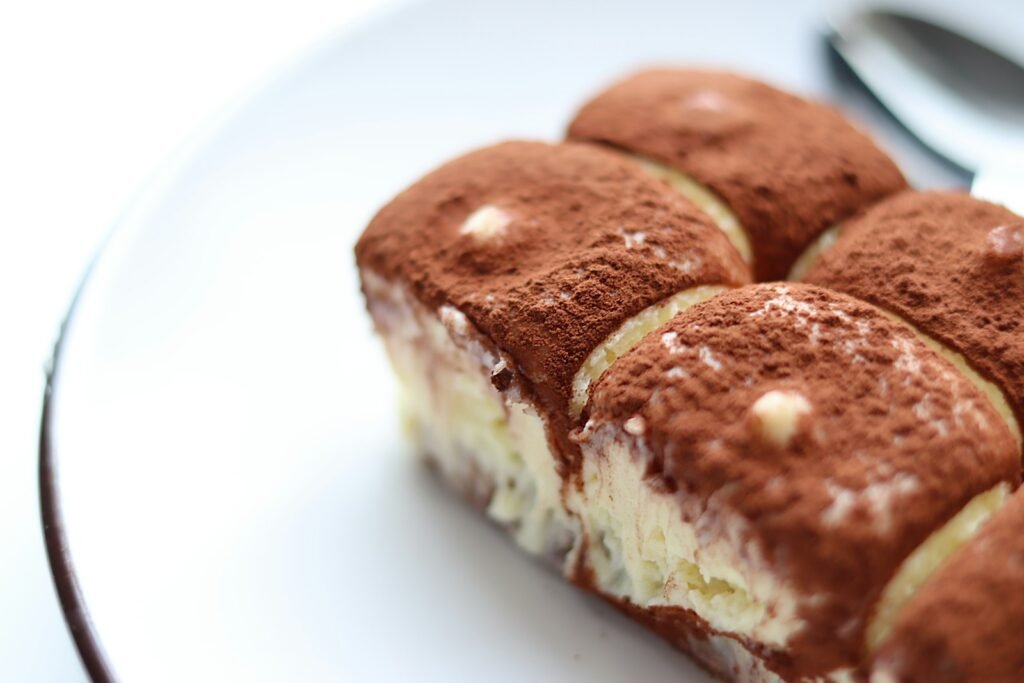 Tiramisú - a white plate topped with four pieces of cake