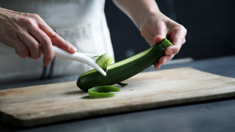 Gestión de Inventario y Reducción de Desperdicios en Cocina - person pealing green cucumber inside room